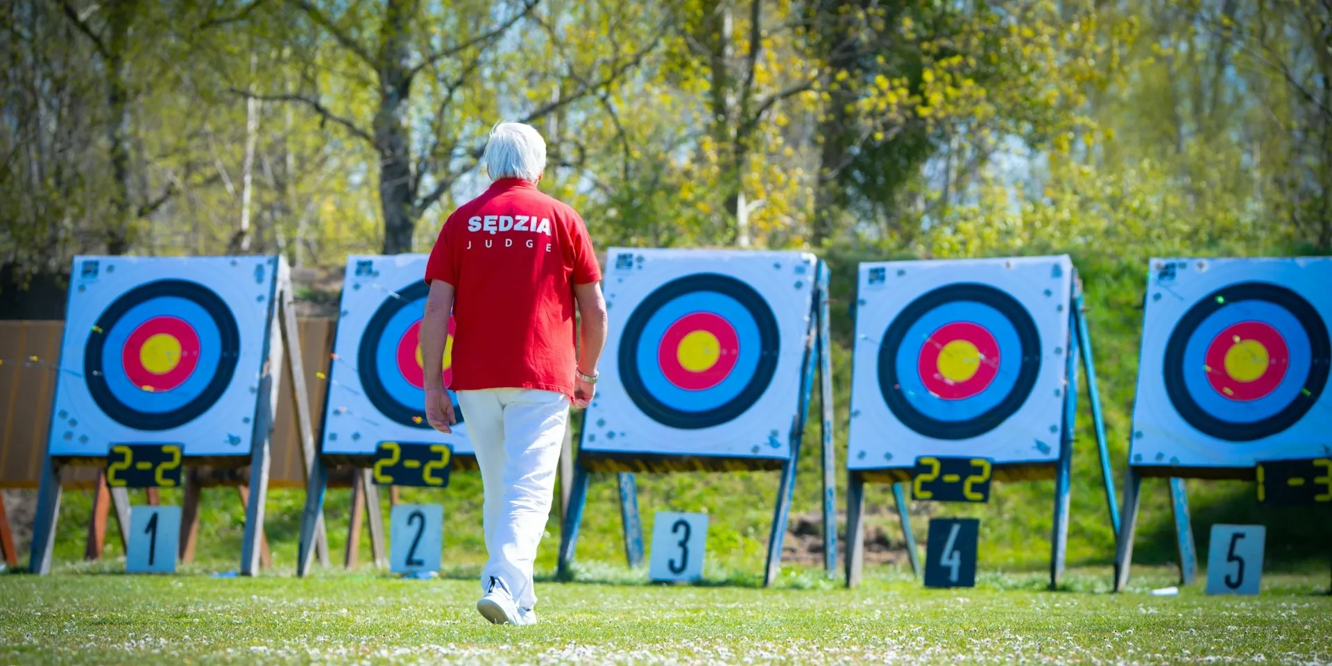 An archery judge reviewing targets, the illustration used for RenX's pay-for-results hiring announcement